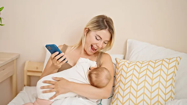 Matka Córka Siedzi Łóżku Karmi Dziecko Przy Użyciu Smartfona Sypialni — Zdjęcie stockowe