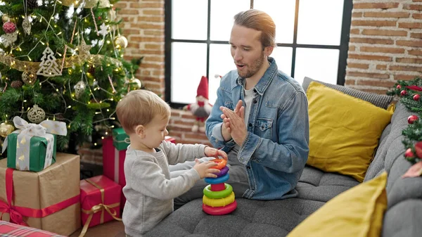 Father and son celebrating christmas playing with toys at home