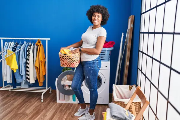 African American Woman Smiling Confident Holding Basket Clothes Laundry Room — Fotografia de Stock