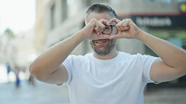 Homem Cabelos Grisalhos Sorrindo Confiante Fazendo Gesto Coração Com Mãos — Fotografia de Stock