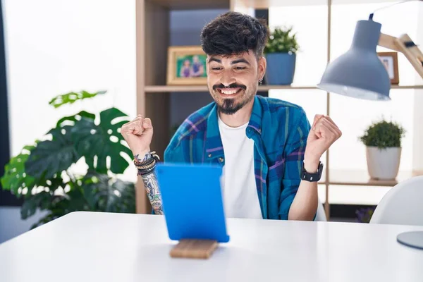 Young Hispanic Man Beard Using Touchpad Sitting Table Screaming Proud — Stock Photo, Image