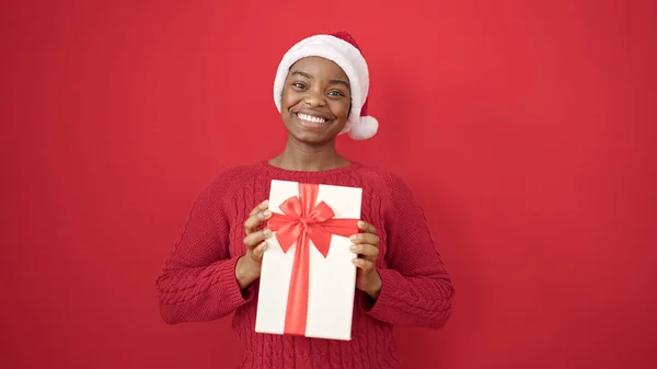 Afrikaans Amerikaanse Vrouw Houden Geschenk Dragen Kerst Hoed Geïsoleerde Rode — Stockfoto