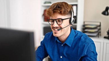 Ofiste kutlama yapmak için bilgisayar ve kulaklık kullanan İspanyol bir iş adamı.