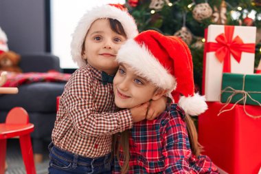 Sevimli kız ve erkek birbirlerine sarılıp Noel 'i evde kutluyorlar.