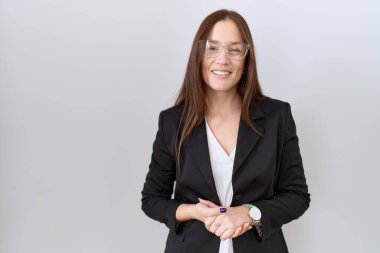 Güzel esmer kadın, iş ceketi ve gözlük takıyor ve ellerini kavuşturup gülümsüyor. Başarı ve iyimserlik 