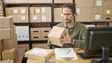 Genç İspanyol adam iş adamı ofiste paket arıyor.