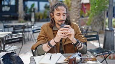 Genç İspanyol turist kahve içiyor kahve dükkanının terasında oturuyor.