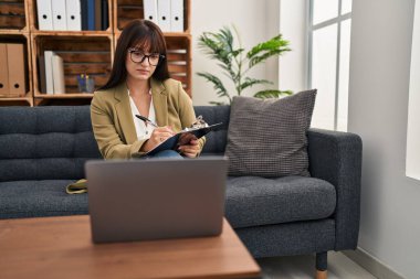 Genç ve güzel İspanyol kadın psikolog psikoloji kliniğinde online seans yapıyor.