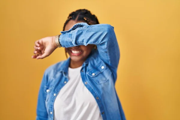 Afroamerykanka Warkoczami Stojąca Nad Żółtym Tłem Okrywająca Oczy Uśmiechem Ramieniu — Zdjęcie stockowe
