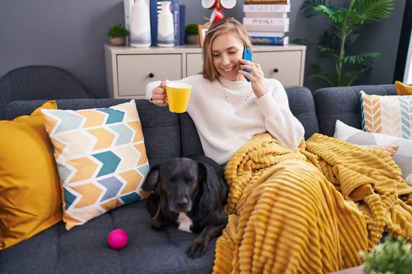 Junge Blonde Frau Spricht Auf Smartphone Kaffee Trinkend Auf Sofa — Stockfoto