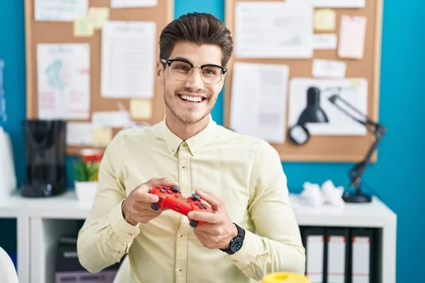 若いヒスパニック系の男ビジネスワーカーがオフィスでビデオゲームをプレイ — ストック写真