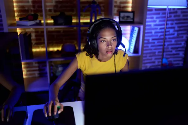 若いアフリカ系アメリカ人女性のストリーマーは ゲームルームでコンピュータを使用してビデオゲームをプレイ — ストック写真