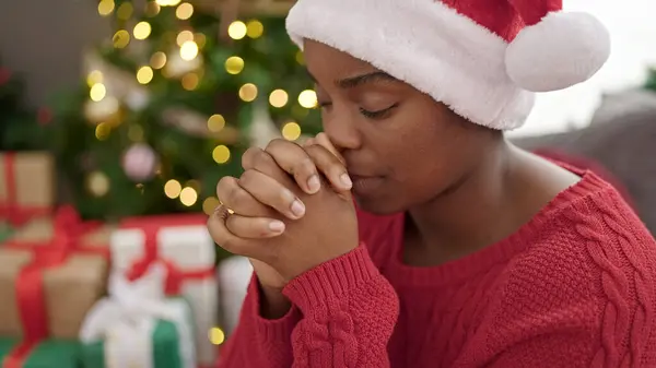 African american woman celebrating christmas praying at home