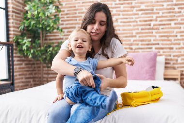 Anne ve oğlu yataklarında oturmuş, çocukları hazırlıyorlar.