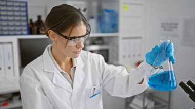 Çekici genç İspanyol bilim kadını test tüpünde sıvıyı ölçüyordu. Telaşlı laboratuarında çığır açan tıbbi araştırmasına dalmış bilimsel çabalarının güzelliğini gösteriyordu..