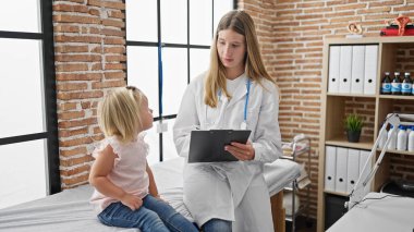 Sevimli çocuk hastası ve ilgili çocuk doktoru birlikte kliniğin rahat odasında oturup detaylı tıbbi rapor yazıyorlar.