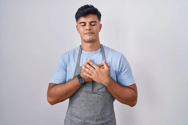 Jovem Hispânico Vestindo Avental Sobre Fundo Branco Sorrindo Com Mãos — Fotografia de Stock