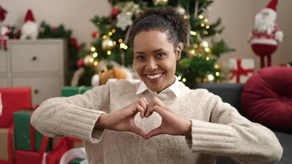 Afro Amerikaanse Vrouw Doet Hart Gebaar Zitten Bank Door Kerstboom — Stockfoto