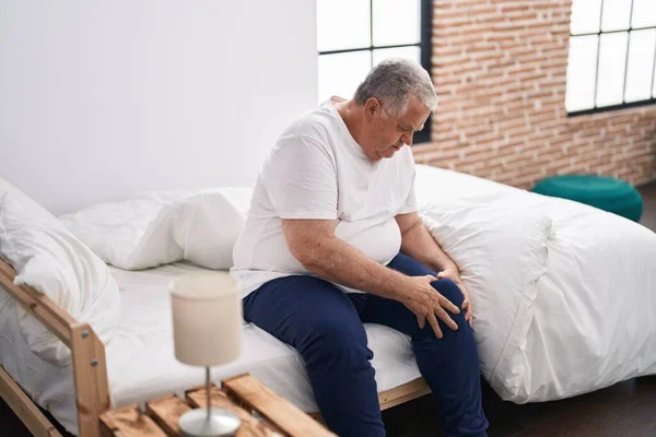 Middle Age Grey Haired Man Suffering Knee Injury Sitting Bed — Stock fotografie