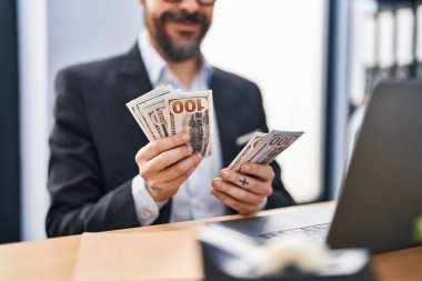 Young bald man business worker counting dollars at office