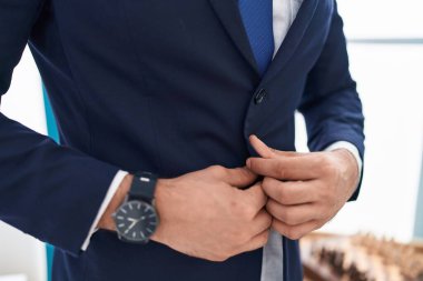 Genç İspanyol iş adamı ofiste ceket giyiyor.