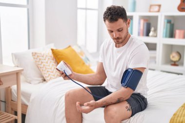 Yatak odasında nabız ölçer kullanan genç bir İspanyol.