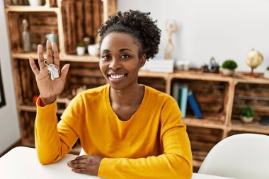 African american woman smiling confident holding key of new house at home