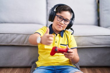 Video oyunu oynayan, kulaklık takan, neşeli ve komik yüzlü İspanyol bir çocuk. iyi enerji ve titreşimler. 