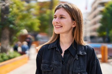 Young blonde woman smiling confident looking to the side at park