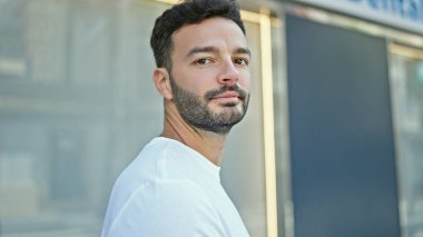 Sokakta ciddi bir ifadeyle duran İspanyol genç adam.