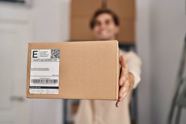 Young caucasian man ecommerce business worker holding package at office