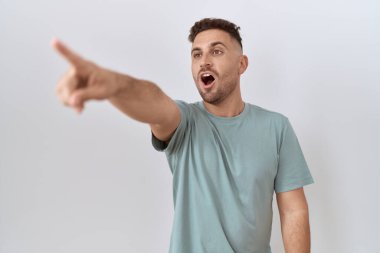 Beyaz arka planda duran İspanyol sakallı adam parmağı önde, ağzı açık, şaşırmış bir ifade, ön tarafta bir şey. 