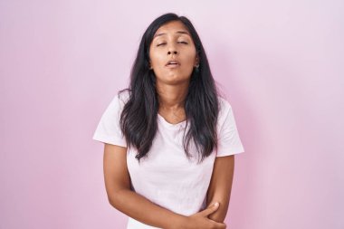 Pembe arka planda duran genç İspanyol kadın uykulu ve yorgun görünüyor, yorgunluktan yorgun ve akşamdan kalma, sabahları tembel gözler.. 