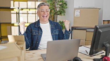 Genç Kafkasyalı iş adamı. Ofiste birinci sınıf jest yapan bir dizüstü bilgisayar kullanıyor.