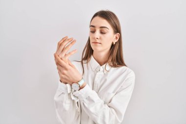 Kafkasyalı genç bir kadın izole edilmiş arka planda duruyor. Ellerinde ve parmaklarında ağrı, eklem iltihabı var. 