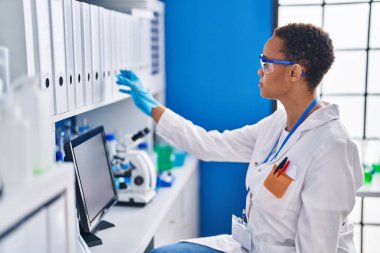 African american woman scientist standing at laboratory