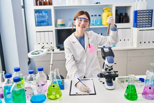 Young Blonde Woman Scientist Analysing Test Tube Writing Clipboard Laboratory — Stock Photo, Image