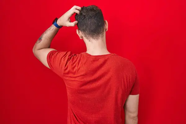 Young Hispanic Man Standing Red Background Backwards Thinking Doubt Hand —  Fotos de Stock