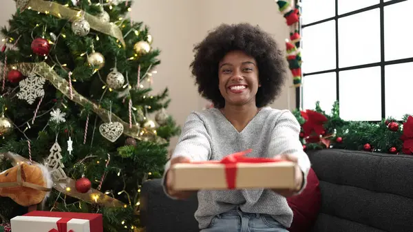 Afrikaans Amerikaans Vrouw Holding Gift Zitten Bank Door Kerstboom Thuis — Stockfoto