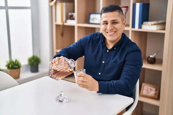 Young Latin Man Pouring Whisky Glass Sitting Table Home — Stock Photo, Image