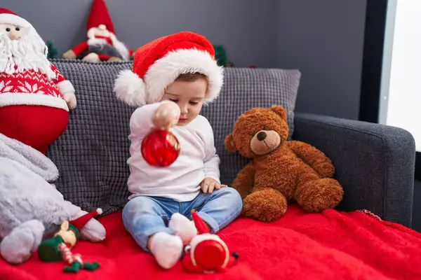 Очаровательный Кавказский Ребенок Играет Рождественским Балом Украшения Сидя Диване Дома — стоковое фото