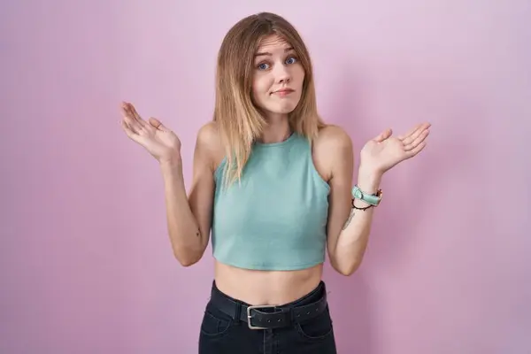 Blonde Caucasian Woman Standing Pink Background Clueless Confused Expression Arms —  Fotos de Stock