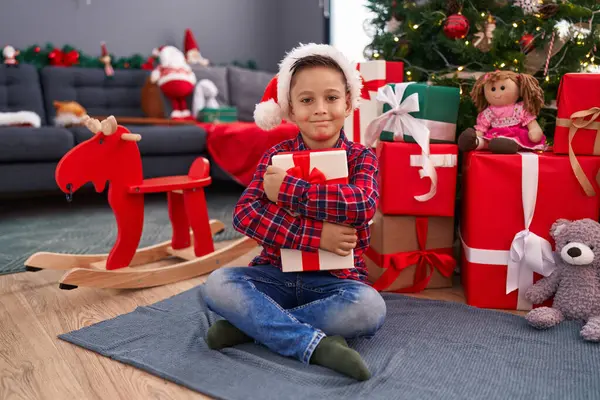 可爱的小男孩抱着圣诞礼物坐在家里的地板上 — 图库照片