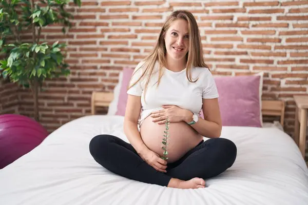 Jonge Zwangere Vrouw Aanraken Buik Holding Plant Slaapkamer — Stockfoto
