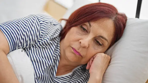 Orta Yaşlı Bir Kadın Yatak Odasında Ciddi Bir Yüzle Yatakta — Stok fotoğraf