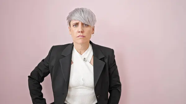 孤立したピンクの背景の上に深刻な顔で立っている若い女性ビジネスワーカー — ストック写真