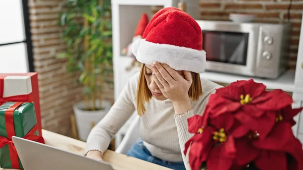 Młoda Blondynka Nosi Świąteczny Kapelusz Pomocą Laptopa Patrząc Zdenerwowany Tarasie — Zdjęcie stockowe