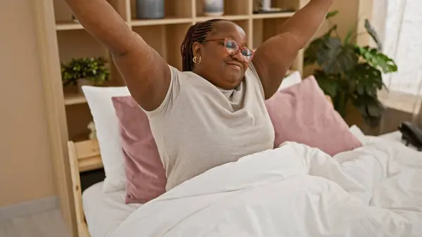 Веселая Африканская Американка Радостно Вытягивает Руки Просыпается Уютной Кровати Расслабляется — стоковое фото