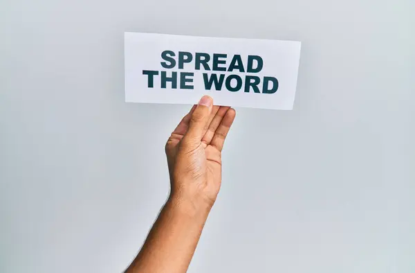 Hand of caucasian man holding paper with spread the word message over isolated white background