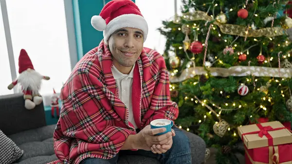 自宅でクリスマスを祝うコーヒーを飲む若いヒスパニックの男 — ストック写真